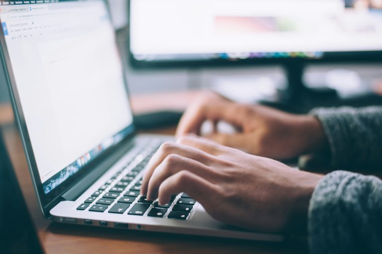 Person typing on a laptop to complete an online certification application