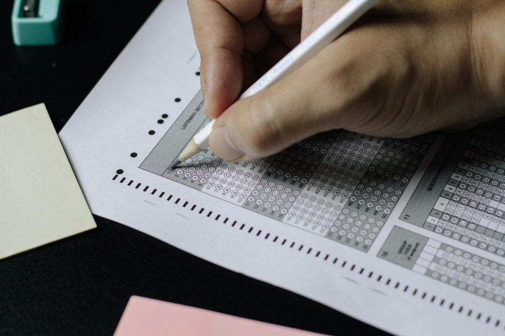 Close-up of a person filling in a bubble-sheet certification exam
